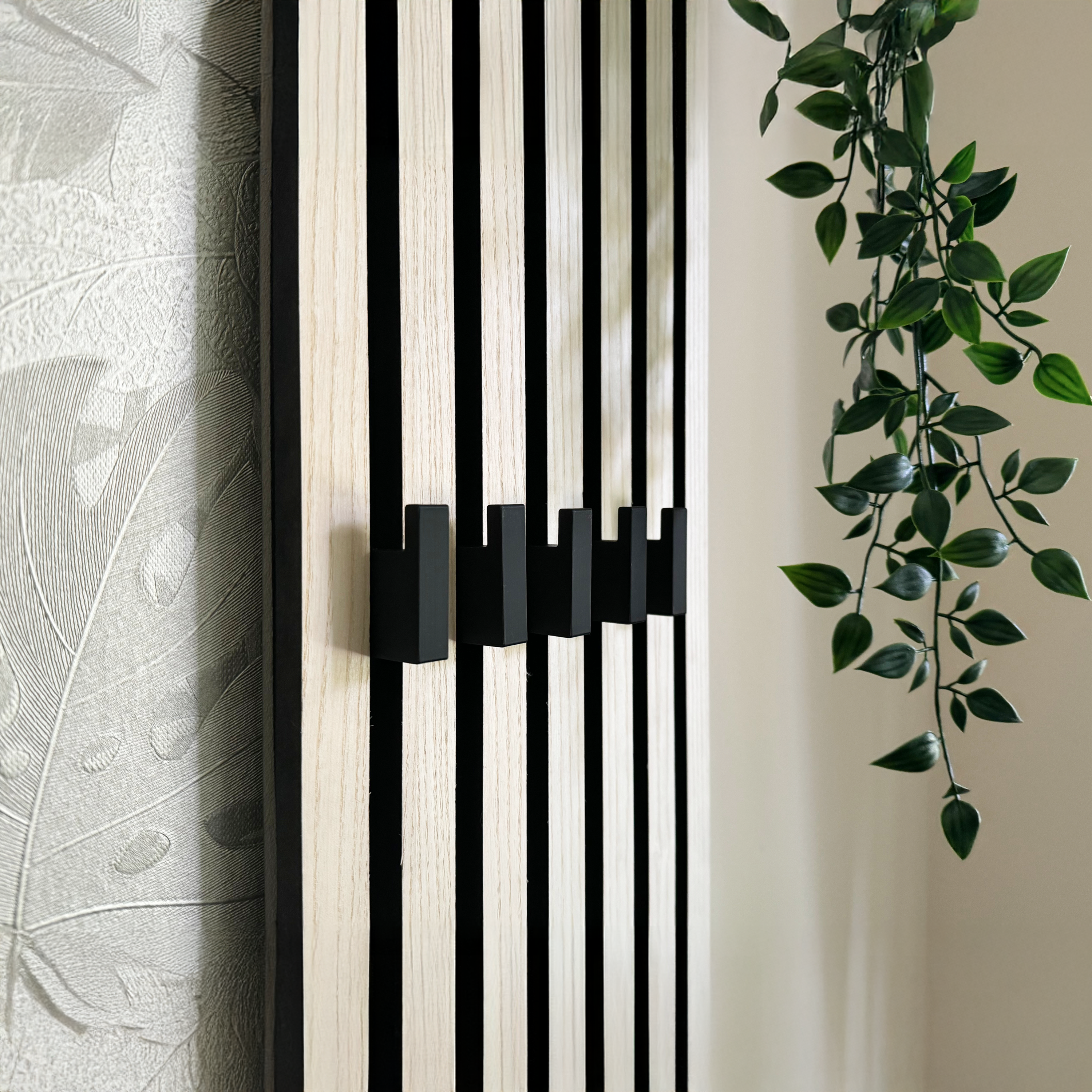 Eleganter Haken an Akustikpaneel zur platzsparenden und ästhetischen Umwandlung in eine Garderobe für Mäntel, Taschen und Accessoires in Büro- und Wohnräumen.