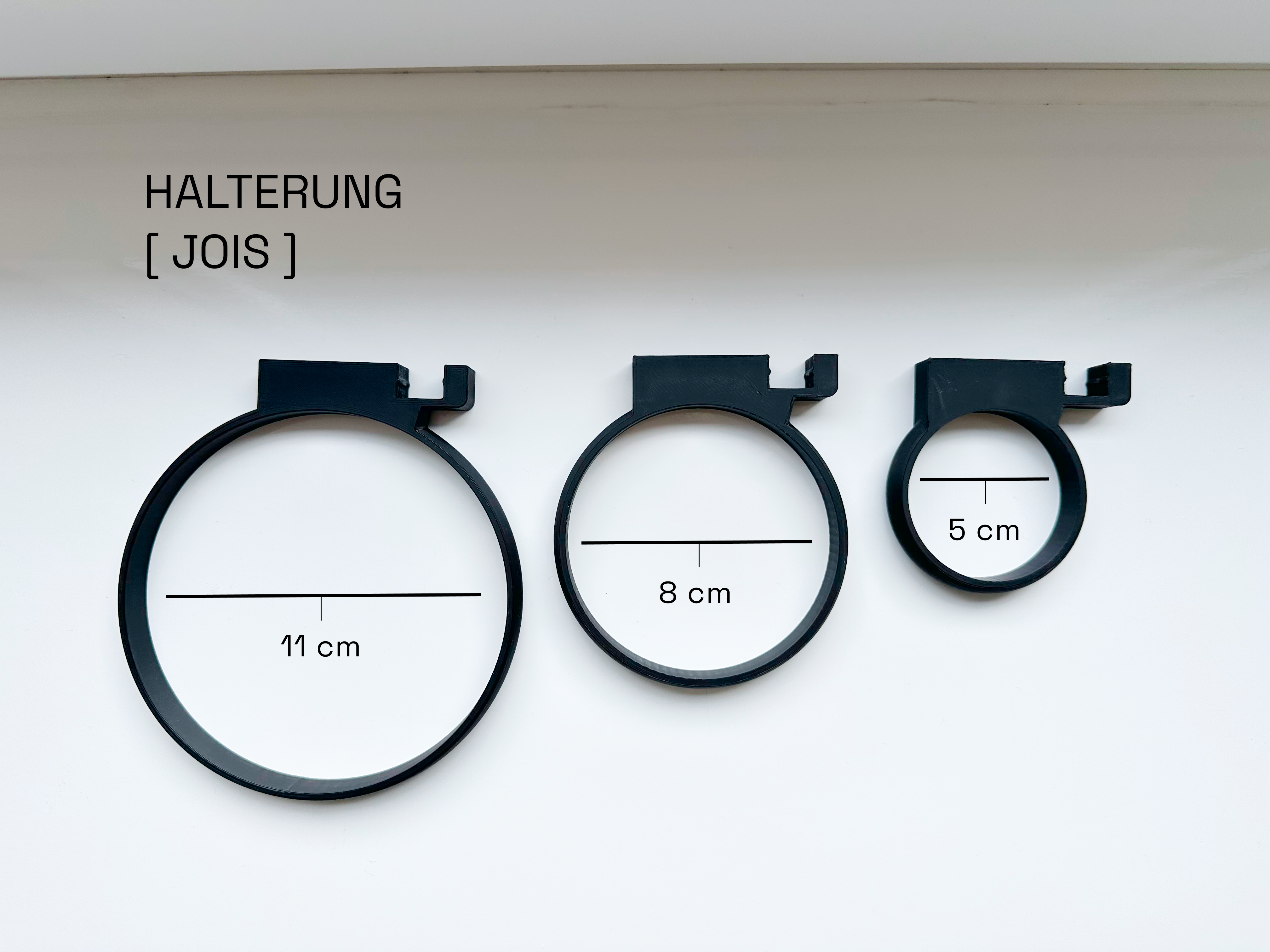 Eleganter Haken an Akustikpaneel, der das Paneel in eine platzsparende und ästhetische Garderobe für Schals, Leinen und Accessoires von Hund und Katze in Büro- und Wohnräumen verwandelt.