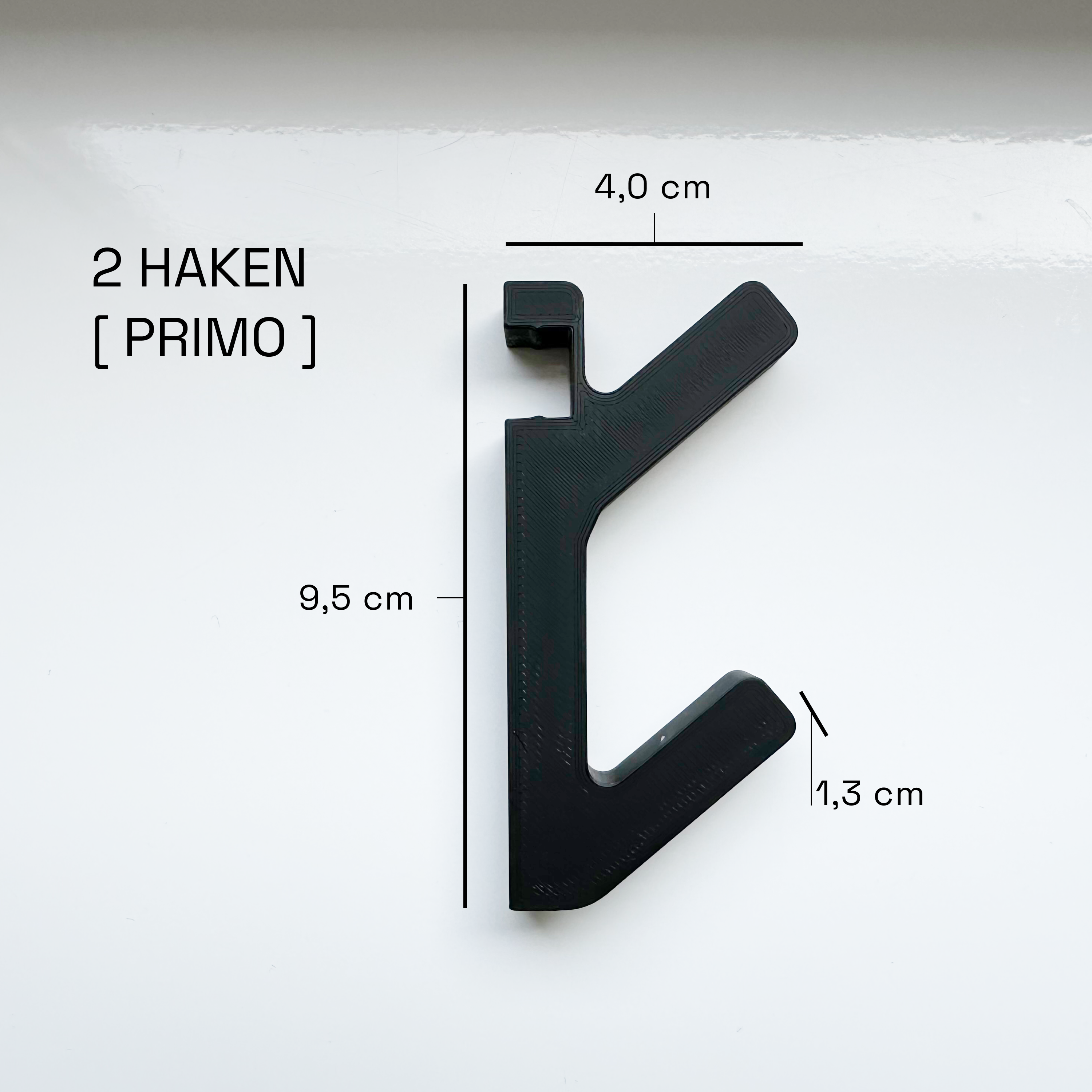 Eleganter Haken an Akustikpaneel zur platzsparenden und ästhetischen Umwandlung in eine Garderobe für Mäntel, Taschen und Accessoires in Büro- und Wohnräumen.